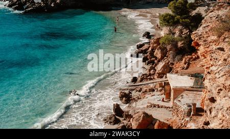 Une vue panoramique sur la plage d'Ibiza avec des cabanes de pêcheurs à la plage Cala Saladeta, Espagne Banque D'Images