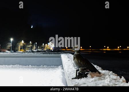 À la jetée de Kolobrzeg, « Marian », une sculpture de mouette, se dresse gracieusement au milieu de l'enchantement d'une nuit d'hiver. Banque D'Images