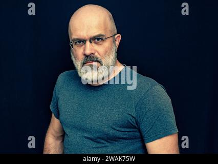 Portrait d'un homme chauve avec une barbe grise. Un homme d'âge moyen regarde la caméra Banque D'Images