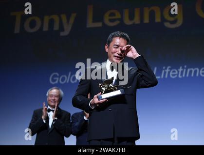 Pékin, Italie. 2 septembre 2023. L'acteur Tony Leung Chiu-Wai de Hong Kong, en Chine, essuie ses larmes lorsqu'il reçoit le Lion d'or pour l'accomplissement de toute une vie lors d'une cérémonie de remise des prix lors du 80e Festival international du film de Venise à Venise, Italie, le 2 septembre 2023. Crédit : Jin Mamengni/Xinhua/Alamy Live News Banque D'Images