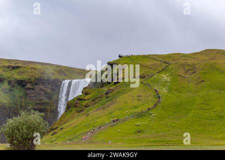 Skogar Islande - 28 juillet 2023 : touristes visitant la cascade de Skogafoss dans le sud de l'Islande Banque D'Images