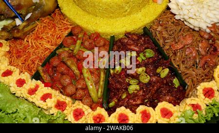 Riz en forme de cône ou appelé Nasi Tumpeng Un plat de riz indonésien festif avec des plats d'accompagnement Banque D'Images