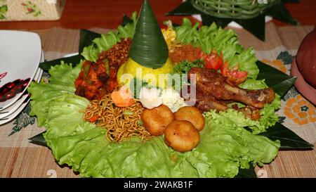 Riz en forme de cône ou appelé Nasi Tumpeng Un plat de riz indonésien festif avec des plats d'accompagnement Banque D'Images