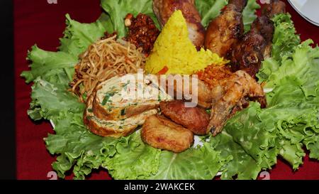 Riz en forme de cône ou appelé Nasi Tumpeng Un plat de riz indonésien festif avec des plats d'accompagnement Banque D'Images