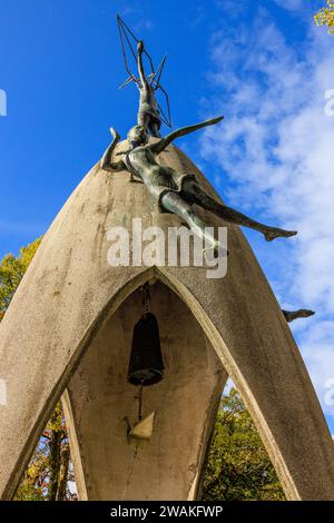 détail du mémorial de la paix des enfants à hiroshima montrant la moitié supérieure avec des statues d'enfants et la cloche de la paix avec un clanger en forme de grue en papier Banque D'Images