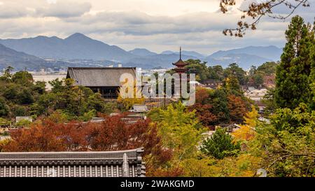 vue depuis la colline de l'île de miyajima du sanctuaire itsukushima et pagode de cinq étages entourée par le feuillage d'automne coloré et les montagnes de hiroshima ba Banque D'Images