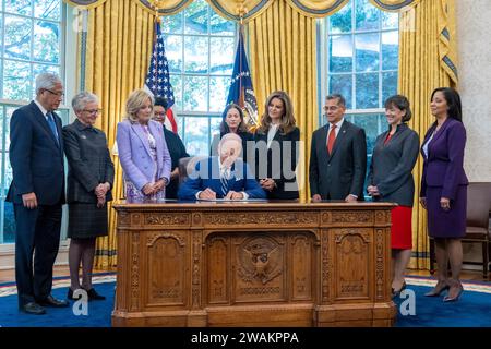 Washington, États-Unis d ' Amérique. 13 novembre 2023. Le président américain Joe Biden, au centre, rejoint par la première dame Jill Biden, à gauche, signe le Mémorandum présidentiel sur la recherche sur la santé des femmes, lors d’une cérémonie au Bureau ovale, le 13 novembre 2023 à Washington, D.C. crédit : Erin Scott/White House photo/Alamy Live News Banque D'Images