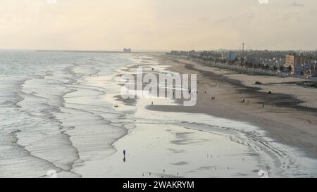 Taqah, salalah- 12 décembre 2023 : personnes jouant au football sur la plage au coucher du soleil Banque D'Images