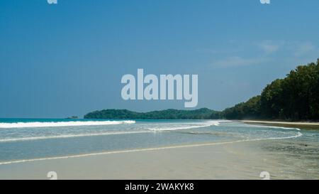 Plage de sable blanc et ciel bleu. Close up vague douce a rodé la plage de sable, fond d'été. Belles vagues de mer avec mousse de couleur bleue et turquoise Banque D'Images