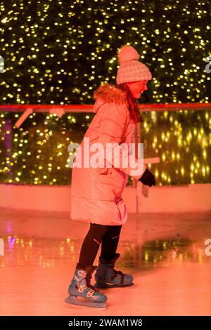 Patineur sur glace patine sur une patinoire saisonnière temporaire de Noël / nouvel an pendant l'hiver, avec arbre de Noël en arrière-plan. Londres. ROYAUME-UNI. (137) Banque D'Images