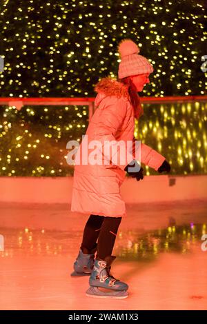 Patineur sur glace patine sur une patinoire saisonnière temporaire de Noël / nouvel an pendant l'hiver, avec arbre de Noël en arrière-plan. Londres. ROYAUME-UNI. (137) Banque D'Images