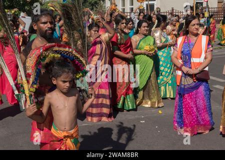 Immigration en Grande-Bretagne, société multiculturelle britannique, communauté hindoue assistent et prennent part à un festival annuel hindou traditionnel Ratha Yatra, Rathayatra ou chariot dans la banlieue de Londres. Père et jeune fils qui participent à maintenir une tradition vivante. Angleterre années 2022 2000 Royaume-Uni HOMER SYKES Banque D'Images