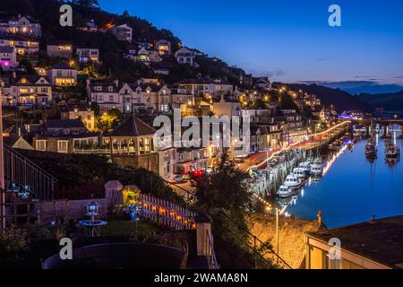 Looe, Cornouailles, Royaume-Uni - 14 août 2023 : Port et ville à l'heure bleue avec des lumières réfléchies dans l'eau Banque D'Images