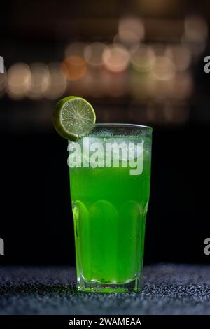 Une boisson verte fraîche avec une tranche de garniture de citron vert servie dans un grand verre Banque D'Images
