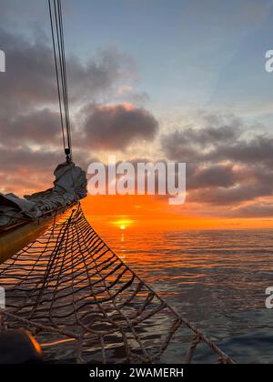Lever de soleil orange sur l'océan Atlantique vu d'une proue de grand voilier Banque D'Images