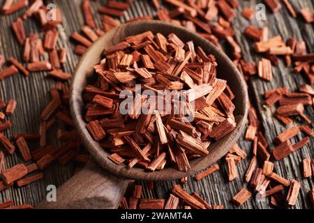 Copeaux de bois de santal rouge sur une cuillère en bois, gros plan Banque D'Images