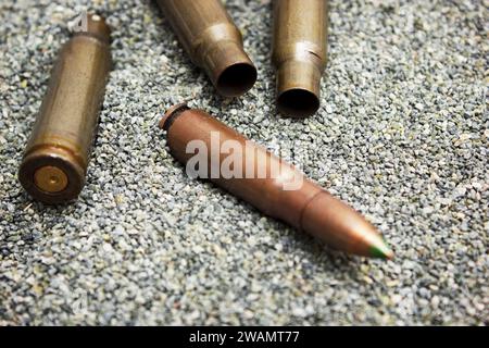 Cartouche avec marque verte pour fusil et cartouches vides trouvées couchées sur le sable Banque D'Images