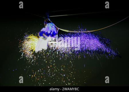 Latina, Italie. 5 janvier 2024. Le Flying Befana disperse des confettis scintillants lorsqu'il descend de la tour de la mairie à l'occasion des célébrations de l'Epiphanie en Latina. Des centaines d'enfants et d'adultes acclamés ont accueilli le Befana qui est descendu de la tour de la mairie à l'occasion des célébrations de l'Epiphanie en Latina. Crédit : ZUMA Press, Inc./Alamy Live News Banque D'Images