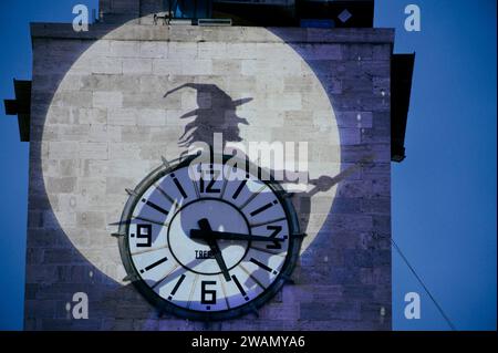 Latina, Italie. 5 janvier 2024. L'ombre du Befana volant projeté sur la tour de la mairie de Latina à l'occasion des célébrations de l'Epiphanie. Des centaines d'enfants et d'adultes acclamés ont accueilli le Befana qui est descendu de la tour de la mairie à l'occasion des célébrations de l'Epiphanie en Latina. Crédit : ZUMA Press, Inc./Alamy Live News Banque D'Images