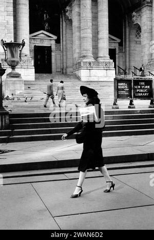 Femme marchant devant la bibliothèque publique de New York, Fifth Avenue, New York City, New York, USA, Angelo Rizzuto, Anthony Angel Collection, septembre 1957 Banque D'Images