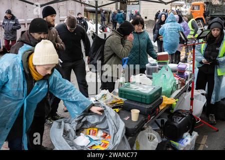 Kiev, Ukraine. 05 janvier 2024. Des volontaires distribuent de la nourriture et des articles d’hygiène aux résidents d’un immeuble résidentiel endommagé par une attaque de missiles russes à Kiev. Au moins 27 personnes ont été hospitalisées et une femme âgée blessée est morte dans une ambulance après un incendie dans un bâtiment de plusieurs étages à la suite d'une attaque à la roquette à Kiev le 2 janvier 2024. Crédit : SOPA Images Limited/Alamy Live News Banque D'Images