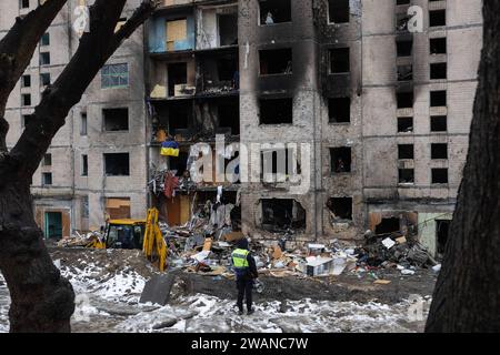 Kiev, Ukraine. 05 janvier 2024. Un officier de police regarde un immeuble résidentiel endommagé par une attaque de missiles russes à Kiev. Au moins 27 personnes ont été hospitalisées et une femme âgée blessée est morte dans une ambulance après un incendie dans un bâtiment de plusieurs étages à la suite d'une attaque à la roquette à Kiev le 2 janvier 2024. (Photo Oleksii Chumachenko/SOPA Images/Sipa USA) crédit : SIPA USA/Alamy Live News Banque D'Images