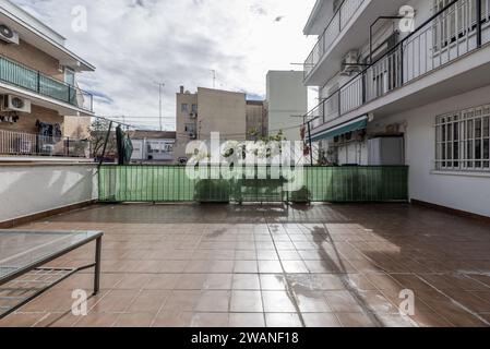 Une grande terrasse dans une maison au rez-de-chaussée dans un immeuble avec balcons au-dessus Banque D'Images