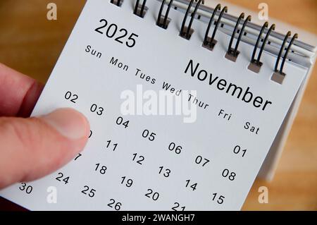 Vue rapprochée du calendrier de novembre 2025 sur fond de bureau en bois. Concept de calendrier. Banque D'Images