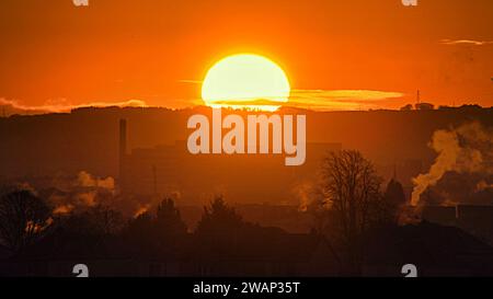 Glasgow, Écosse, Royaume-Uni. 6 janvier 2024. UK Météo : nuit glaciale avec un ciel clair a vu un lever de soleil rouge froid sur le sud-est de la ville. Crédit Gerard Ferry/Alamy Live News Banque D'Images