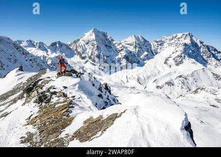 Alpiniste debout sur une corniche devant les montagnes enneigées, sommet de Madritschspitze, derrière Königsspitze, Zebrù et Ortler, Alpes Ortler, ITA Banque D'Images