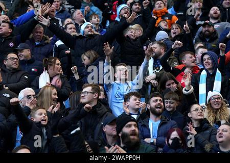 Les fans de Coventry City célèbrent le premier but de leur équipe, marqué par Joel Latibeaudiere (non représenté) lors du match du troisième tour de la coupe FA Emirates au Coventry Building Society Arena, Coventry. Date de la photo : samedi 6 janvier 2024. Banque D'Images