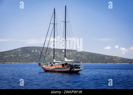 Un catamaran s’est arrêté dans une crique aux eaux calmes et turquoise à quelques kilomètres du port de Bodrum Banque D'Images