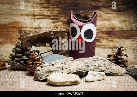 hibou en carton avec fond en bois et pierres Banque D'Images