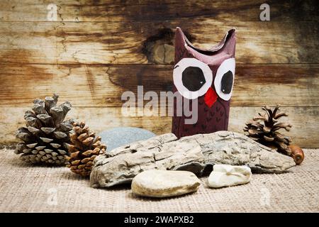 hibou en carton avec fond en bois et pierres Banque D'Images