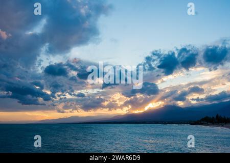 Coucher de soleil coloré sur la mer. Lac de montagne dans les rayons du soleil orange. Kirghizistan, lac Issyk-Kul. arrière-plan naturel. Paysage Banque D'Images