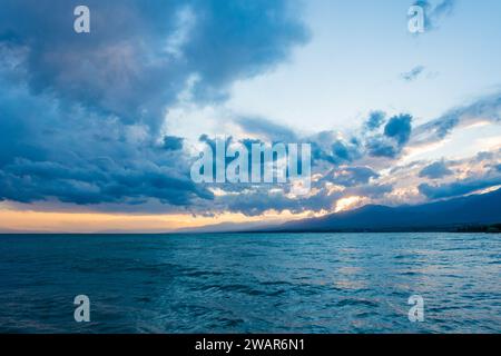 Coucher de soleil coloré sur la mer. Lac de montagne dans les rayons du soleil orange. Kirghizistan, lac Issyk-Kul. arrière-plan naturel. Paysage Banque D'Images