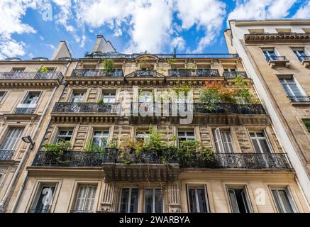 Aperçu d'un immeuble résidentiel typique et élégant dans la rue Molière, centre-ville de Paris, France, avec balustrades en fer forgé et balcons Banque D'Images