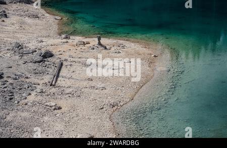 Une scène tranquille avec un plan d'eau, avec un rivage rocheux, avec en toile de fond une chaîne de montagnes majestueuse Banque D'Images