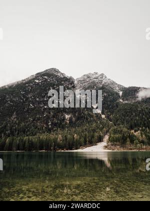 Une vue panoramique sur un lac tranquille entouré de majestueux sommets montagneux, avec plusieurs petits bateaux flottant dans l'eau Banque D'Images