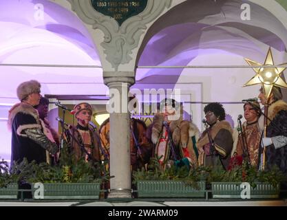 Dreikönigsingen und Glöcklerlauf am Rathausplatz in Gmunden, im oberösterreichischen Salzkammergut, am 05.01.2024. Sowohl das Dreikönigssingen als auch der Glöcklerlauf sind alte, eingeprägte Brauchtumsveranstaltungen im Salzkammergut in Österreich. Während des Glöcklerlaufs tragen junge Burschen prächtig geschmückte Laternenkappen mit meist lokalen Motiven am Kopf. Dabei wird durch laufen, springen und tanzen, mit an Gürteln der weiß Gekleideten angebrachten Glocken, entsprechend Lärm gemacht und dazu gesungen damit treiben die Glöckler in der letzten Rauhnacht der saison, dem 5,1. eines jede Banque D'Images