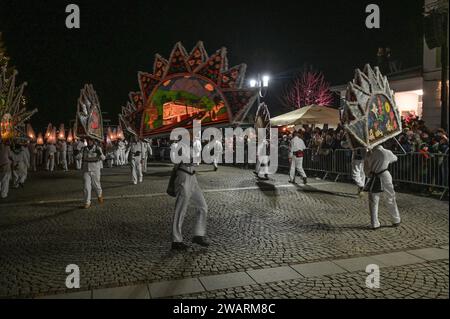 Dreikönigsingen und Glöcklerlauf am Rathausplatz in Gmunden, im oberösterreichischen Salzkammergut, am 05.01.2024. Sowohl das Dreikönigssingen als auch der Glöcklerlauf sind alte, eingeprägte Brauchtumsveranstaltungen im Salzkammergut in Österreich. Während des Glöcklerlaufs tragen junge Burschen prächtig geschmückte Laternenkappen mit meist lokalen Motiven am Kopf. Dabei wird durch laufen, springen und tanzen, mit an Gürteln der weiß Gekleideten angebrachten Glocken, entsprechend Lärm gemacht und dazu gesungen damit treiben die Glöckler in der letzten Rauhnacht der saison, dem 5,1. eines jede Banque D'Images