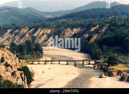 Comté de Vrancea, Roumanie, env. 1975. Vue sur la vallée de la rivière Putna, avec le vieux pont en bois au village de Poduri. Banque D'Images