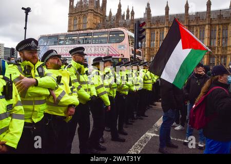 Londres, Royaume-Uni. 06 janvier 2024. Les policiers forment un cordon pendant la manifestation sur le pont Westminster. Des milliers de manifestants pro-palestiniens ont défilé à Westminster pour réclamer un cessez-le-feu alors que la guerre entre Israël et le Hamas se poursuit. Crédit : SOPA Images Limited/Alamy Live News Banque D'Images