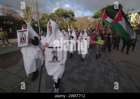 Plus de 200 personnes ont défilé à travers Bournemouth pour un cessez-le-feu à Gaza le 6 janvier 2024. Avec beaucoup vêtus de blanc et les noms d'enfants tués à Gaza, la marche était une image visuelle puissante, exigeant un cessez-le-feu à Gaza. La marche a bloqué la route Pier Approach, où des fusées éclairantes étaient allumées. La marche était organisée par Palestine Solidarity Bournemouth. Banque D'Images