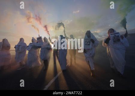 Plus de 200 personnes ont défilé à travers Bournemouth pour un cessez-le-feu à Gaza le 6 janvier 2024. Avec beaucoup vêtus de blanc et les noms d'enfants tués à Gaza, la marche était une image visuelle puissante, exigeant un cessez-le-feu à Gaza. La marche a bloqué la route Pier Approach, où des fusées éclairantes étaient allumées. La marche était organisée par Palestine Solidarity Bournemouth. Banque D'Images