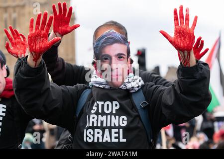 Londres, Royaume-Uni. 6 janvier 2024. Un activiste aux mains couvertes de faux sang porte un masque du Premier ministre britannique Rishi Sunak alors que la Coalition pour la Palestine libre organise une manifestation bloquant le pont de Westminster exigeant un cessez-le-feu immédiat, la fin des ventes d'armes britanniques à Israël et la fin de l'occupation israélienne de la Palestine. Crédit : Ron Fassbender/Alamy Live News Banque D'Images