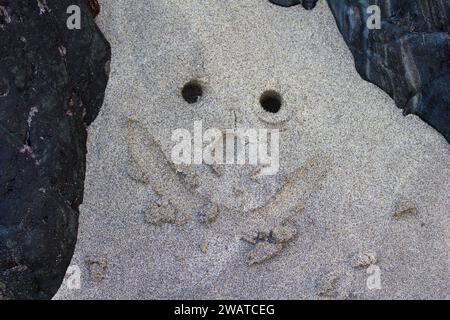 Sourire sablonneux dessiné dans le sable de Kennack Sands, péninsule de Lizard, Cornouailles Banque D'Images