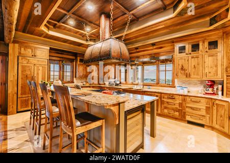 Cette cuisine moderne dispose d'armoires en bois jumelées avec des comptoirs en granit et des seatingv Banque D'Images