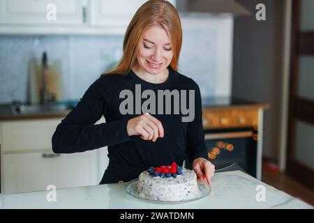 fille décore le gâteau maison avec des baies Banque D'Images