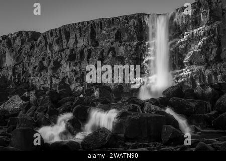Paysage en noir et blanc de la cascade Oxararfoss dans le parc national de Thingvellir, Islande. Oxararfoss cascade est la célèbre cascade attirant Banque D'Images
